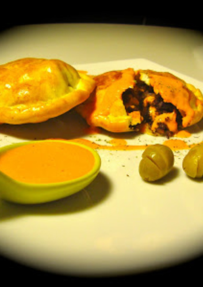 Una foto de Empanadillas de morcilla y pera con salsa de piquillos