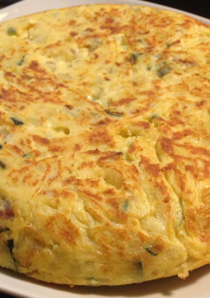 Una foto de Tortilla de patata, calabacín y cebolla roja