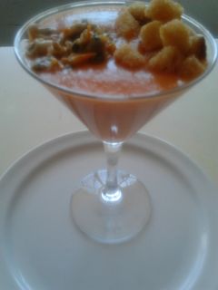 Una foto de Copa de crema fría de tomate con berberechos y daditos de pan crujientes