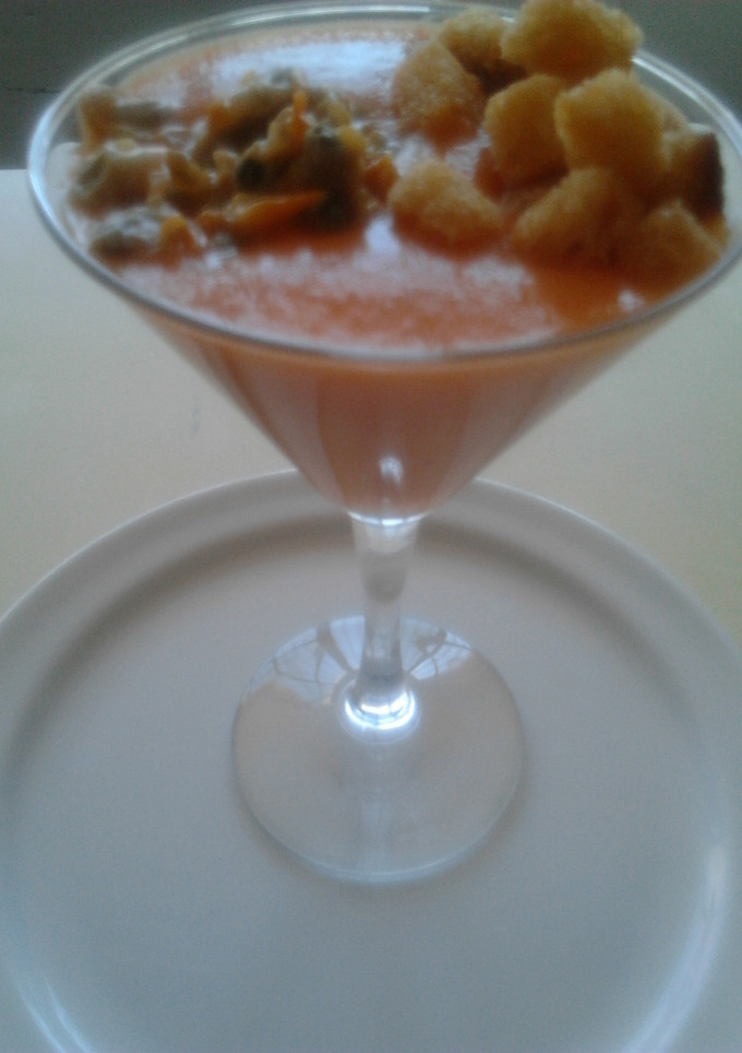 Una foto de Copa de crema fría de tomate con berberechos y daditos de pan crujientes