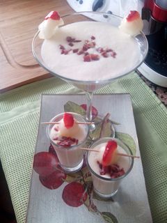 Una foto de Copa o chupito de crema de melón con jamón, bola de melón y pétalo de fresa