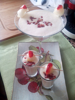 Una foto de Copa o chupito de crema de melón con jamón, bola de melón y pétalo de fresa