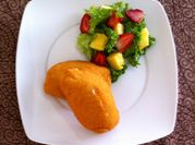 Una foto de ensalada de pollo y frutas