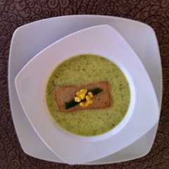 Una foto de Crema de poblano con crocante de elote
