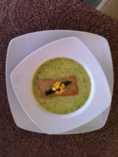 Una foto de Crema de poblano con crocante de elote