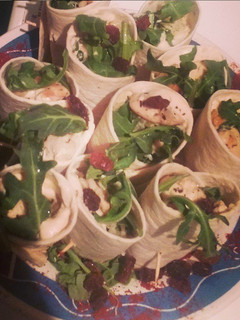Una foto de Rollitos de pollo, humus y rúcula
