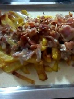 Una foto de Patatas fritas con salsa de nata y bacon