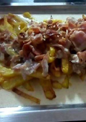 Una foto de Patatas fritas con salsa de nata y bacon