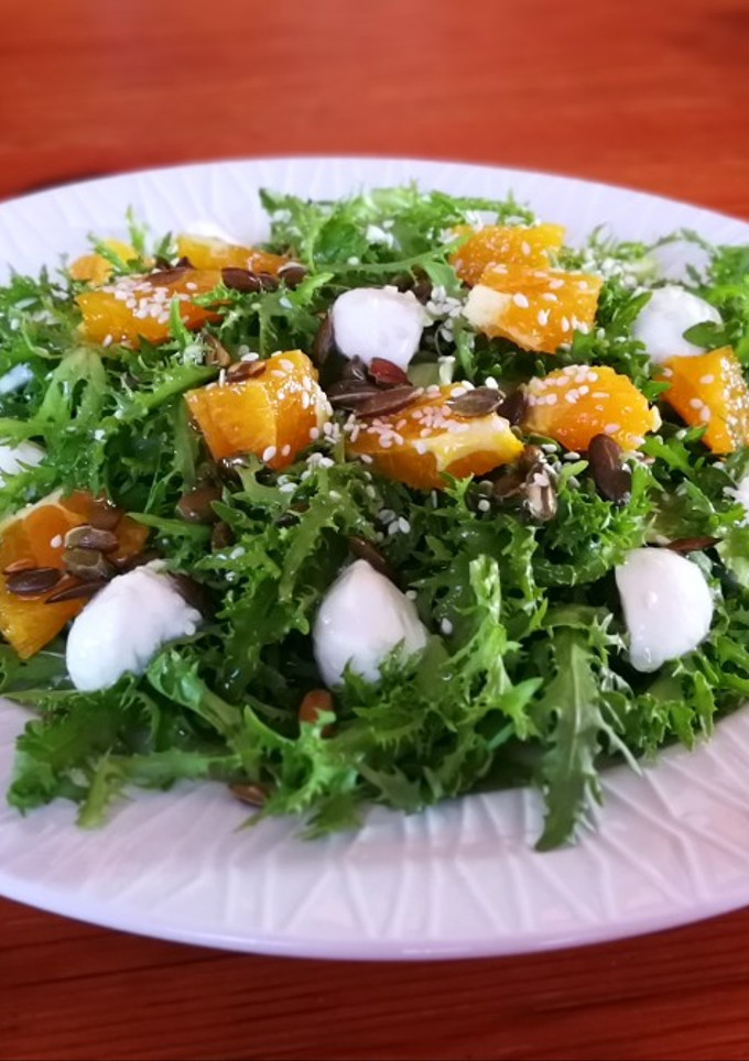 Una foto de Escarola con naranja, semillas y mozzarella