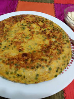 Una foto de Tortilla de patatas, calabacín y guisantes