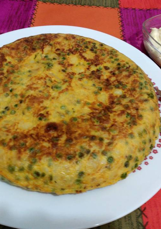 Una foto de Tortilla de patatas, calabacín y guisantes