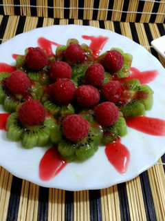 Una foto de Fruta, flores de kiwi y frambuesas.