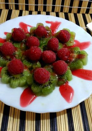 Una foto de Fruta, flores de kiwi y frambuesas.