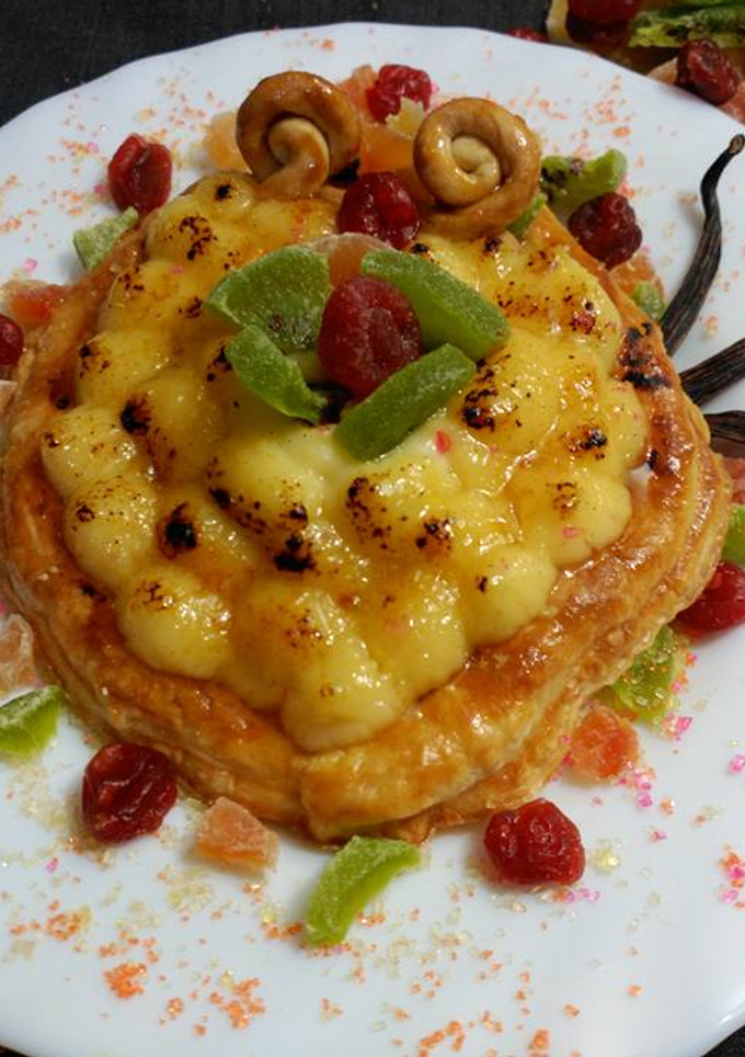 Una foto de Tartaleta de crema de yema y vainilla ,con azucar quemada y fruta confitada.