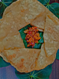 A picture of Aloo poori with tomato chutney.