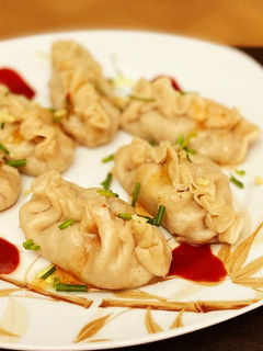 Una foto de Gyozas caseras mixtas con mahonesa de soja, mahonesa de siracha y chili dulce
