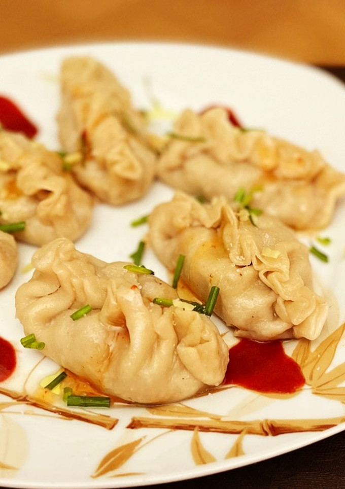 Una foto de Gyozas caseras mixtas con mahonesa de soja, mahonesa de siracha y chili dulce