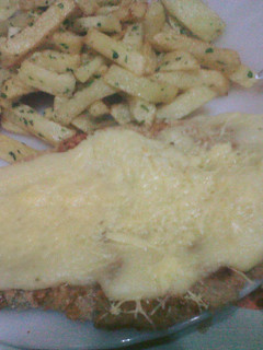 Una foto de Milanesa a la suiza con papas a la provenzal