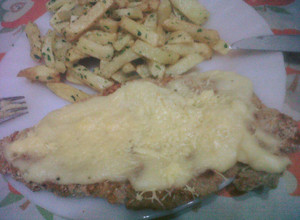 Una foto de Milanesa a la suiza con papas a la provenzal