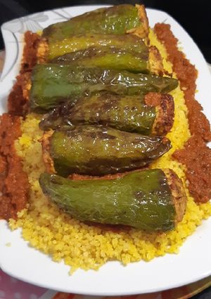 Une photo de Poivrons Farcis accompagnés de boulgour et sauce tomate