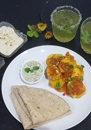 A picture of Aloo kutly with roti,kheer and mint margariya.
