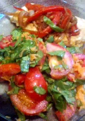 Una foto de Pechuga fileteada con ensalada de espinaca y tomates 