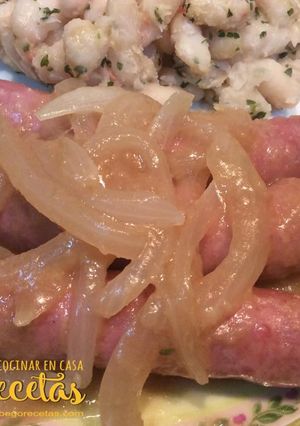Una foto de Salchichas encebolladas con alubias blancas salteadas