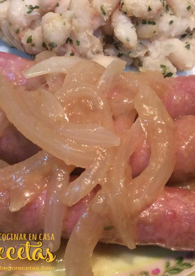 Una foto de Salchichas encebolladas con alubias blancas salteadas