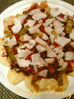 Una foto de Cama de patatas chips con pimientos y bacalao.