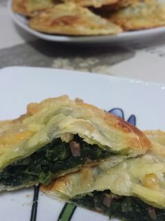 Una foto de Empanadillas rellenas de queso y espinacas salteadas con virutas de jamón