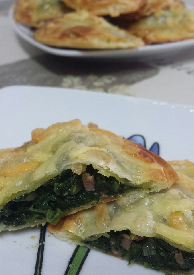 Una foto de Empanadillas rellenas de queso y espinacas salteadas con virutas de jamón