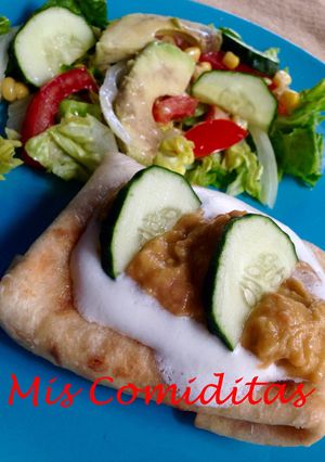 Una foto de CHIMICHANGA DE POLLO CON NATA AGRIA Y GUACAMOLE ACOMPAÑADA DE ENSALADA MEJICANA
