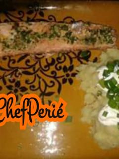 Una foto de Salmón en mantequilla de ajo y cilantro con puré de papas y crema agria.