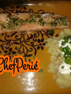 Una foto de Salmón en mantequilla de ajo y cilantro con puré de papas y crema agria.