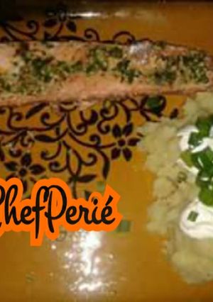 Una foto de Salmón en mantequilla de ajo y cilantro con puré de papas y crema agria.