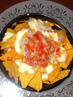 Una foto de Nachos con queso cheddar