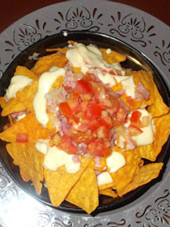 Una foto de Nachos con queso cheddar