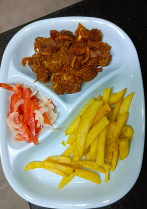 A picture of Goat Meat Dry Fry with Fries and Kachumbari.