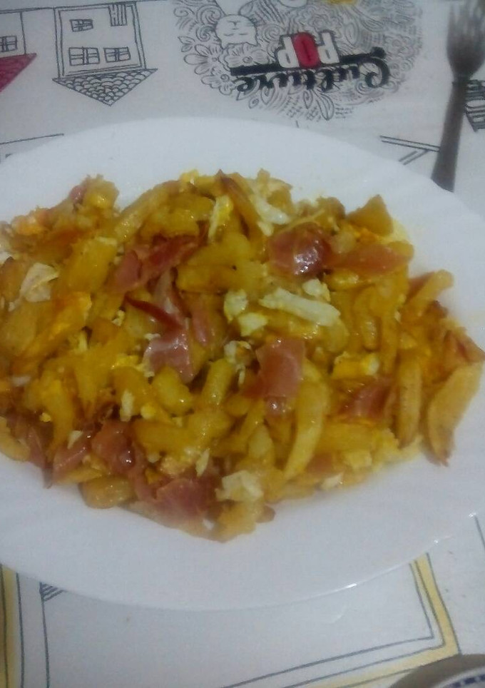Una foto de Patatas con jamón y huevos rotos 