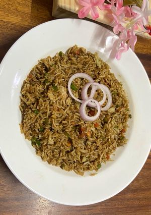 A picture of Desi style fried rice with green chutney.