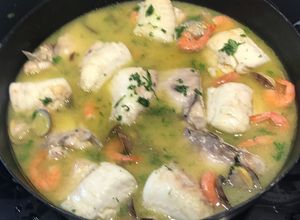 Una foto de Cogote de merluza de anzuelo en salsa verde con gambas y almejas