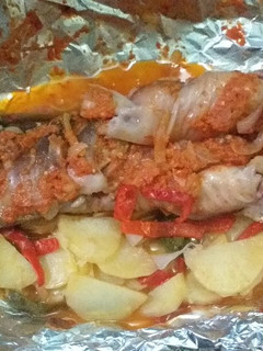 A picture of Grilled fish with potatoes and vegetables.