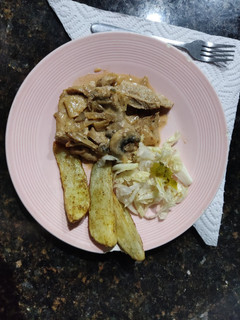 Una foto de Cerdo,manzana,cebolla y champiñones con papas rústicas y lechuga