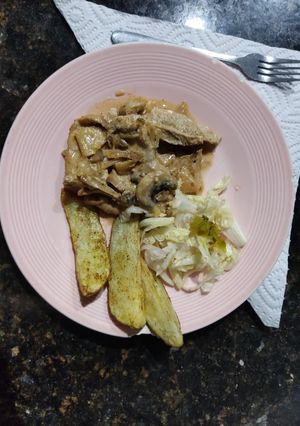 Una foto de Cerdo,manzana,cebolla y champiñones con papas rústicas y lechuga