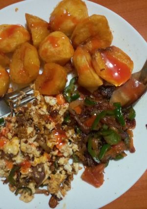 A picture of Roasted potatoes served with fried eggs & veges.