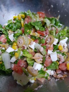 Una foto de Ensalada de atún con aceitunas, tomate, maíz y queso