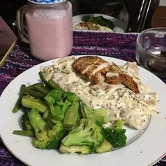 A picture of White sauce pasta with baked chicken.