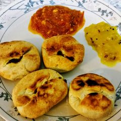 A picture of Baked onion kachodi with spicy chutney & mango chutney.