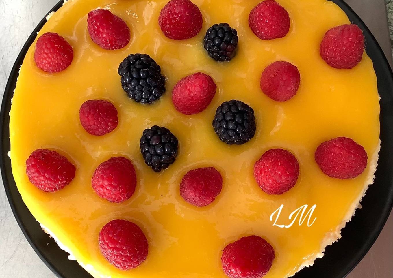 Cheesecake con cobertura de mango y frambuesas