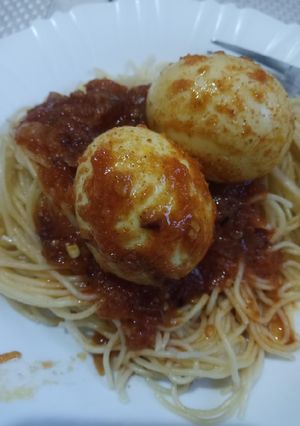 A picture of Egg curry with spaghetti.